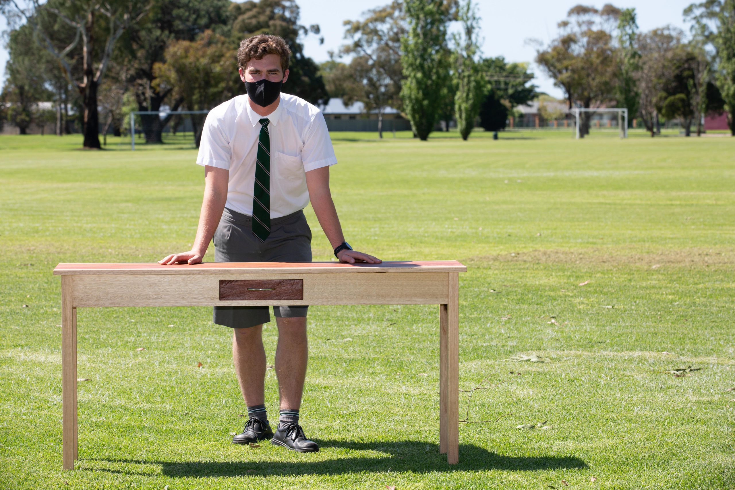 Tom Condron with the side table he built in Furnishing while completing the subject as part of his VCE at Gippsland Grammar in 2021. The table features red gum which Tom sourced from his family farm.