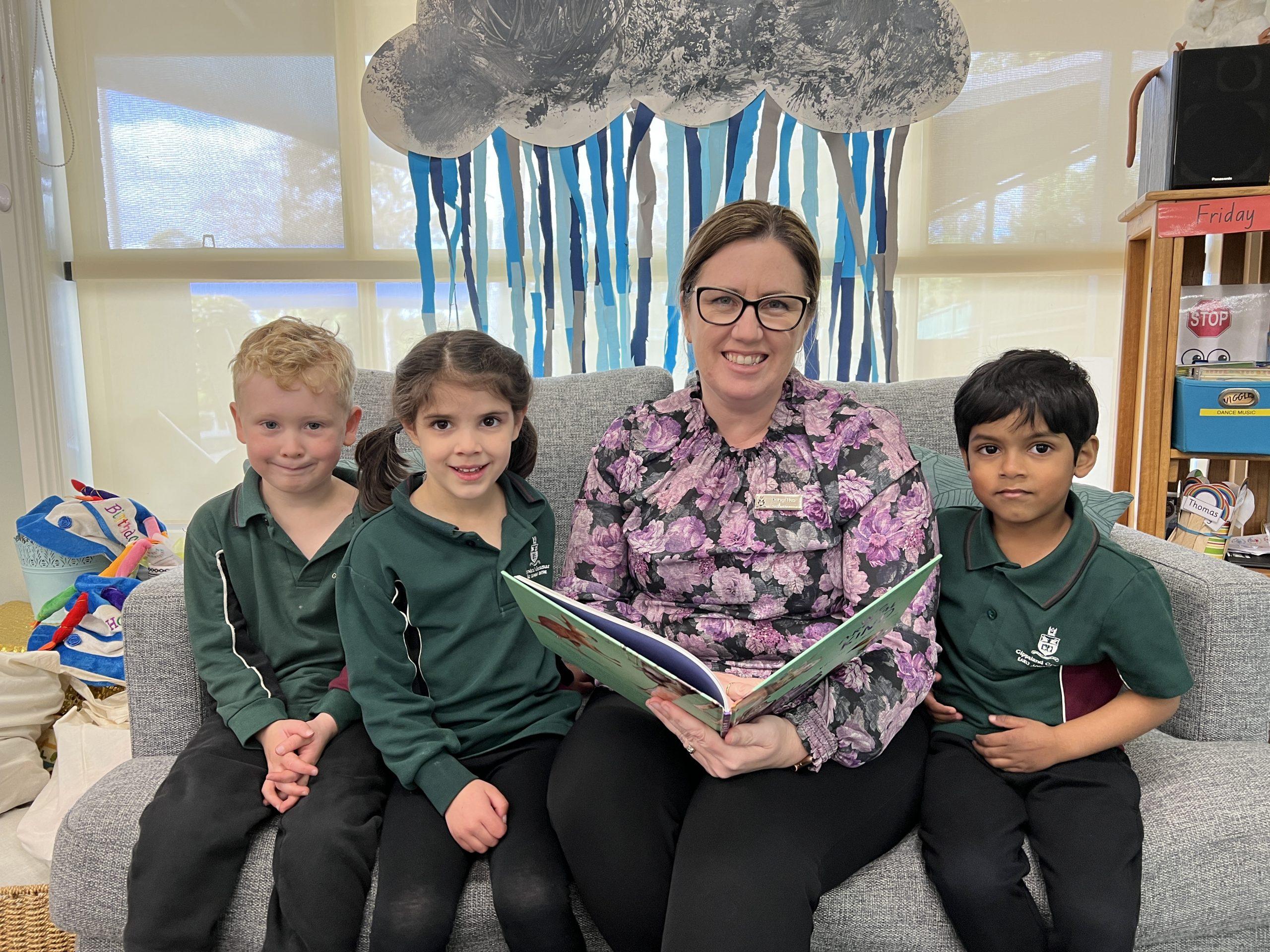 Gippsland Grammar ELC teacher Kristy How reads a book to Transition students Riley, Lucy and Aryan.